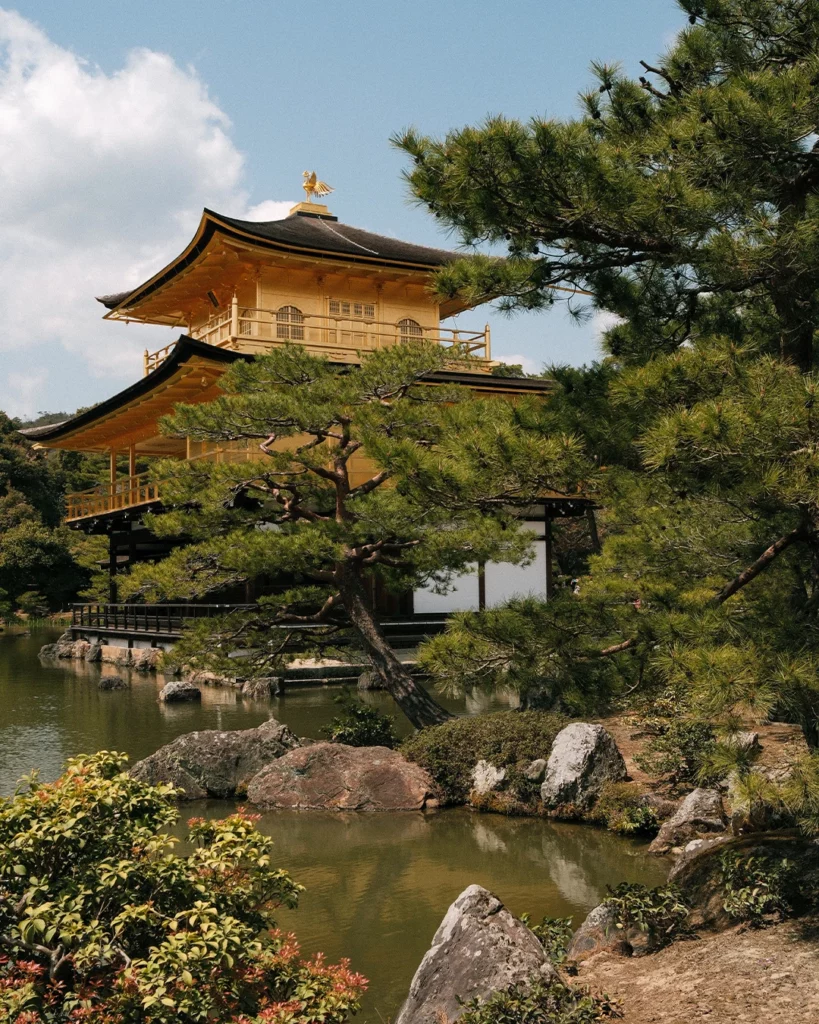 Gouden paviljoen Kinkaku-ji tussen bomen in Kyoto