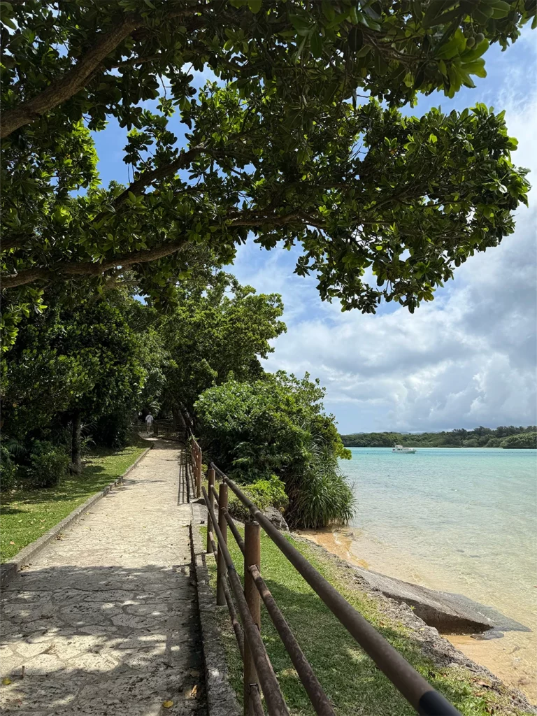 Wandelpad langs het turquoise water van Kabira Bay op Ishigaki Island met tropische bomen en rustige natuur in Okinawa, Japan
