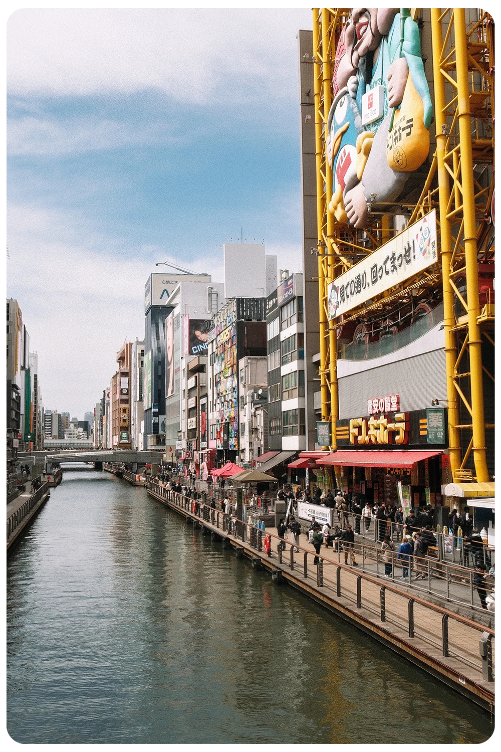 Uitzicht over de Dotonbori-rivier met neonreclames en drukke straten in Osaka, Japan