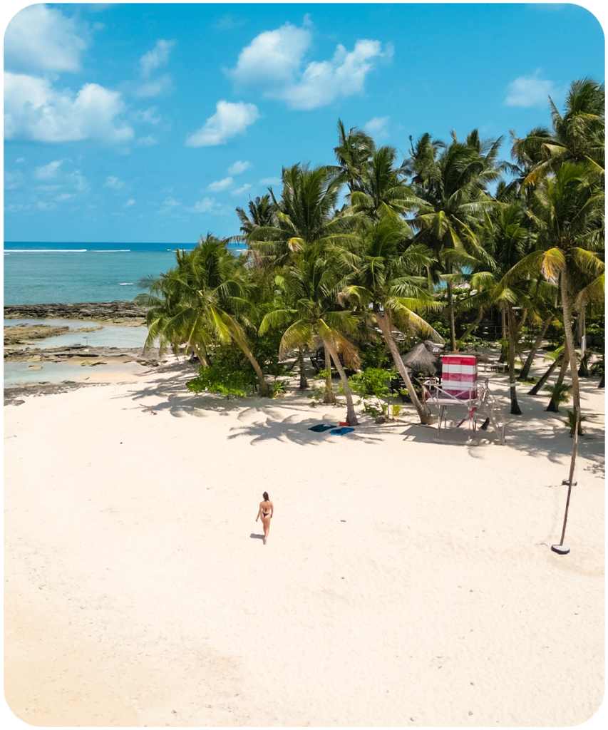 Luchtfoto van Guyam Island op Siargao, Filipijnen met een wit strand, palmbomen en twee bangka boten in het heldere turkooise water