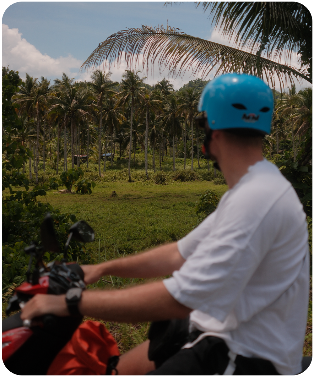 Scooter rijden door de groene palmbomen en tropische natuur van Siargao, Filipijnen