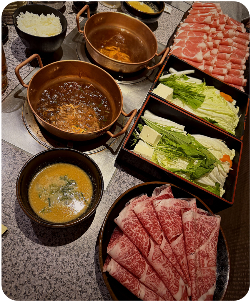 Japanse hotpot met dungesneden wagyu vlees, verse groenten en dashi bouillon in koperen pannen