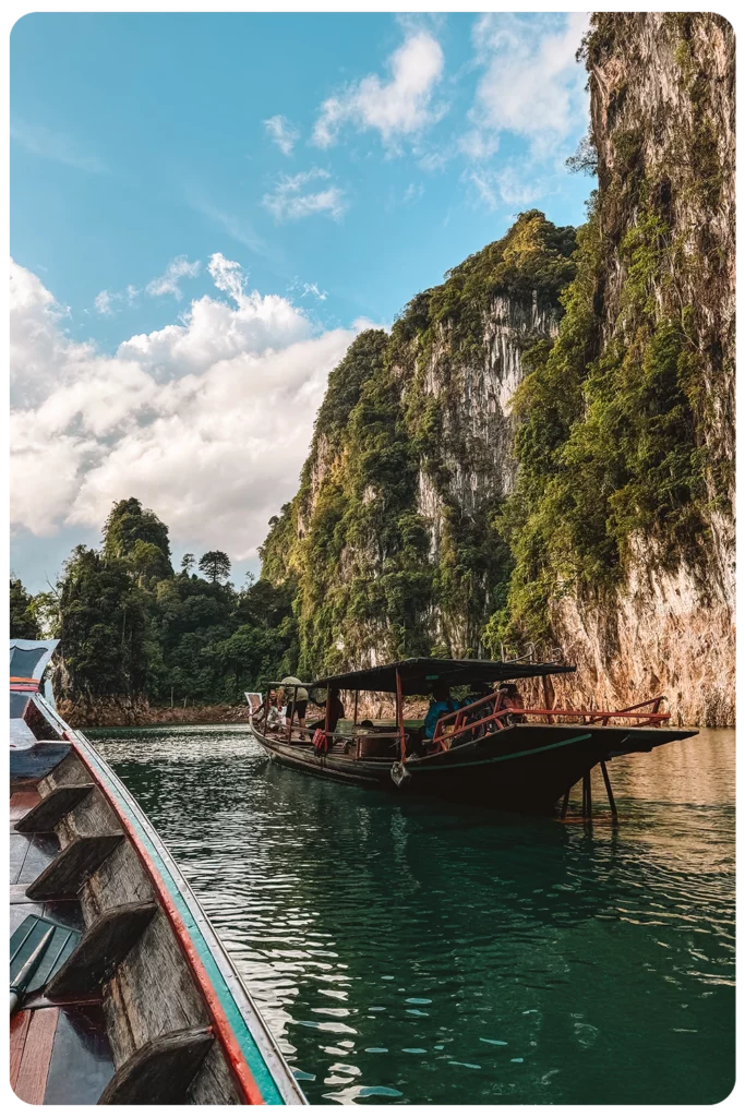 Boten op een meer tussen kalkstenen rotsen in Khao Sok National Park