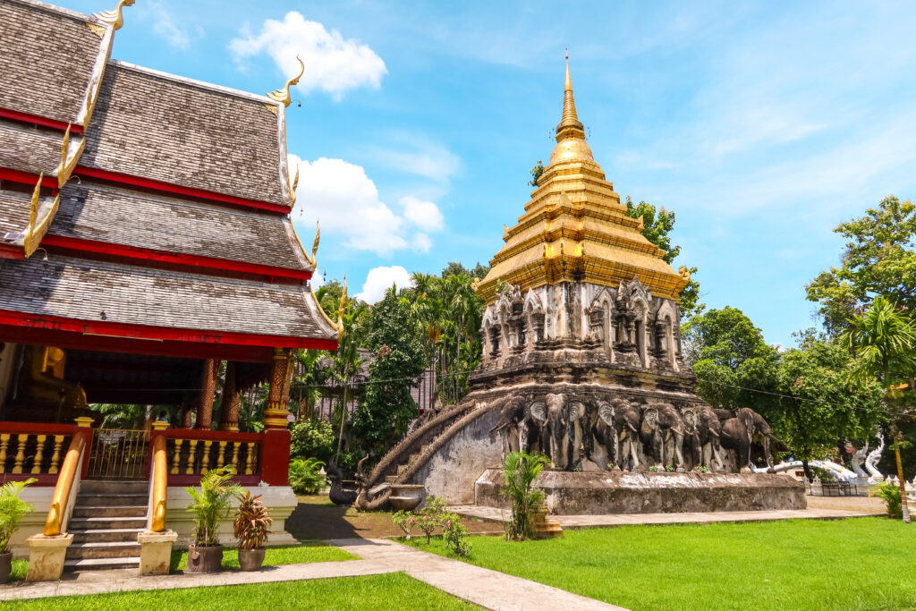 Gouden tempelgebouw met een trap en omliggende gebouwen in Thailand
