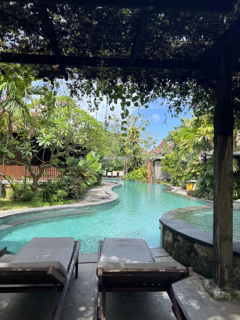 Zwembad tussen tropische bomen bij een verblijf in Sanur op Bali