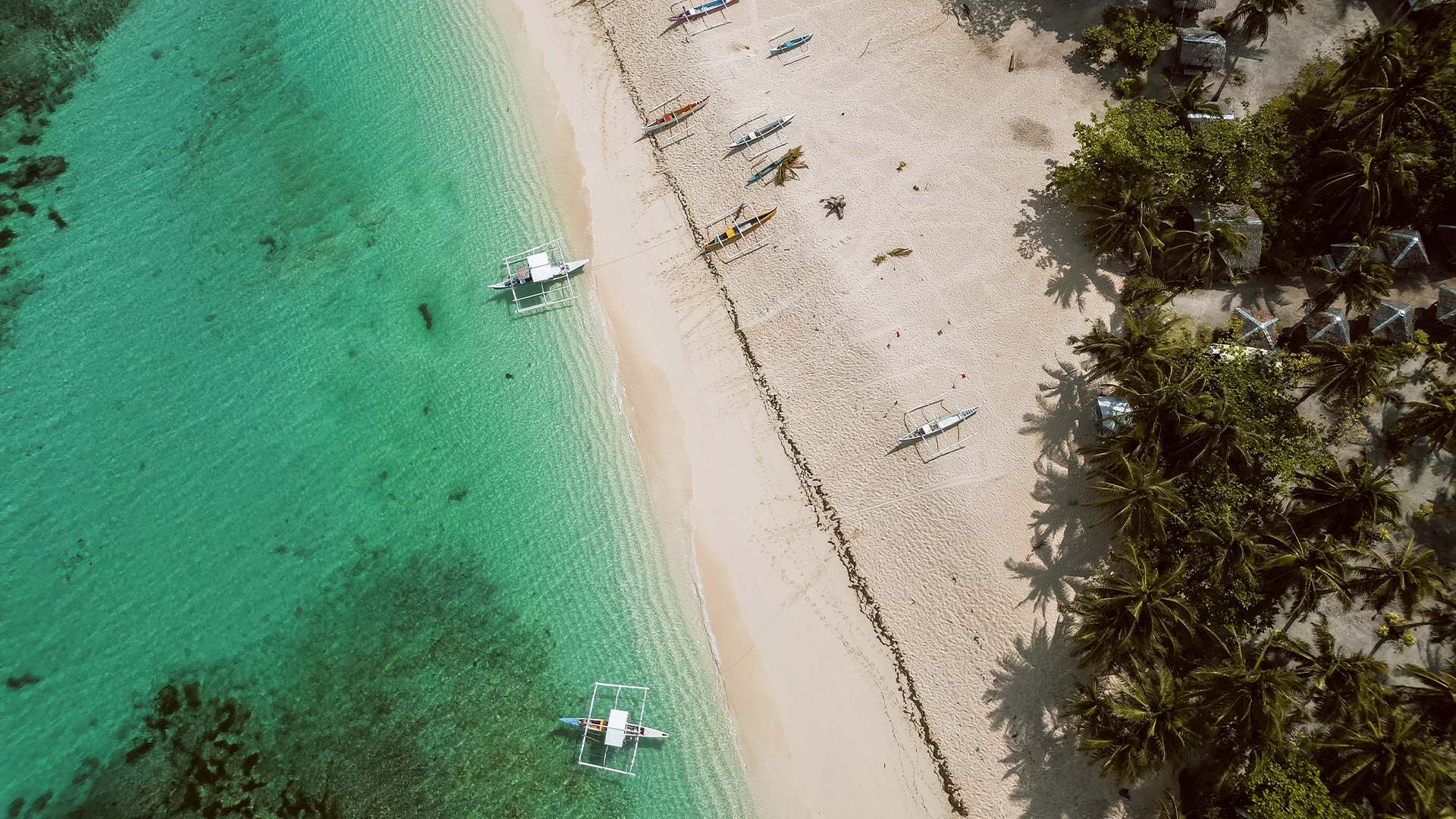 Luchtfoto van een tropisch strand met boten in het zeewater