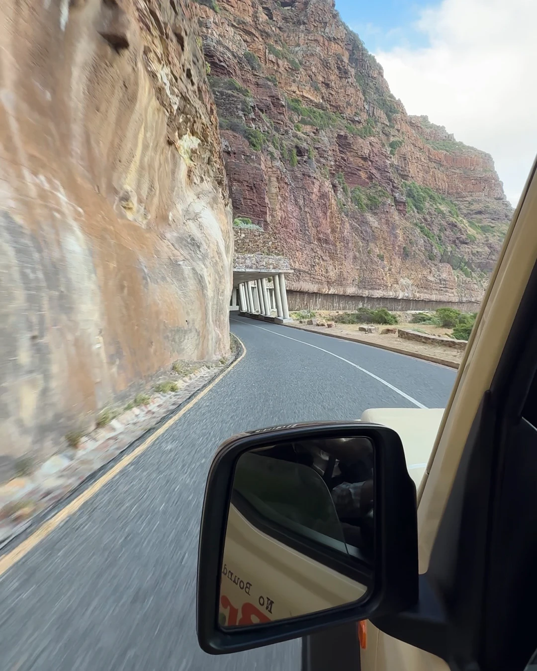 Uitzicht vanuit de auto op de kustweg langs Chapmans Peak in Zuid-Afrika