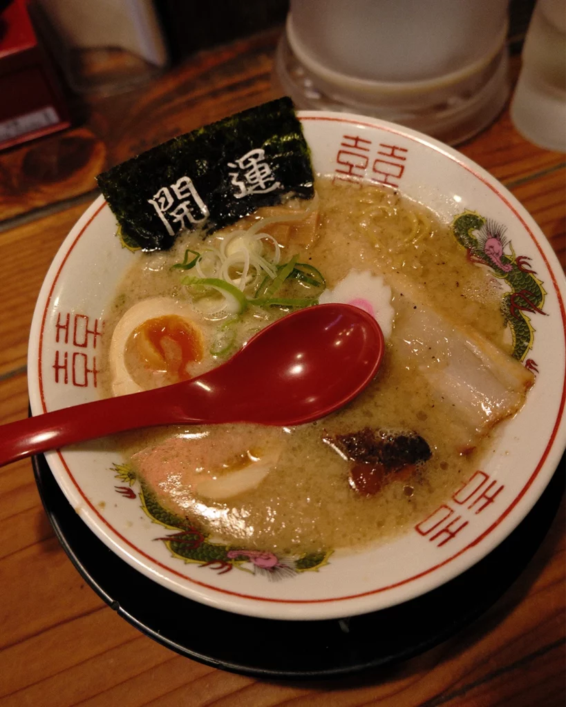Kom ramen met bosui en een rode lepel bij Hanamaruken Hozenji in Osaka
