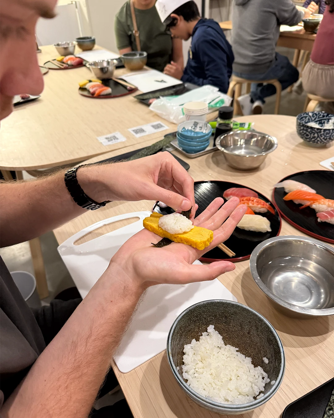 Deelnemer maakt sushi tijdens een kookles in Japan