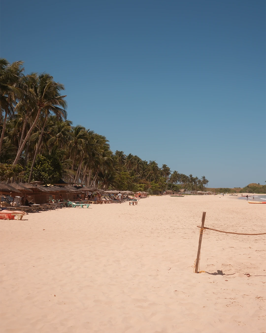 Rustig zandstrand met palmbomen bij Nacpan Beach op Palawan